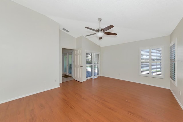 spare room with lofted ceiling, hardwood / wood-style flooring, a wealth of natural light, and ceiling fan