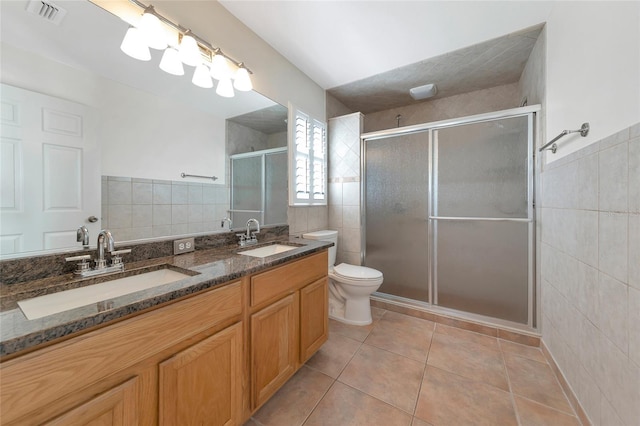 bathroom featuring tile walls, tile patterned flooring, a shower with door, and toilet