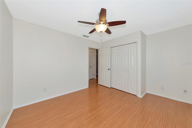 unfurnished bedroom featuring ceiling fan, a closet, and light hardwood / wood-style flooring