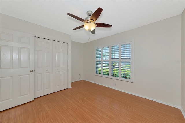 unfurnished bedroom with ceiling fan, a closet, and light hardwood / wood-style flooring