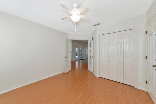 unfurnished bedroom with light hardwood / wood-style floors, a closet, and ceiling fan