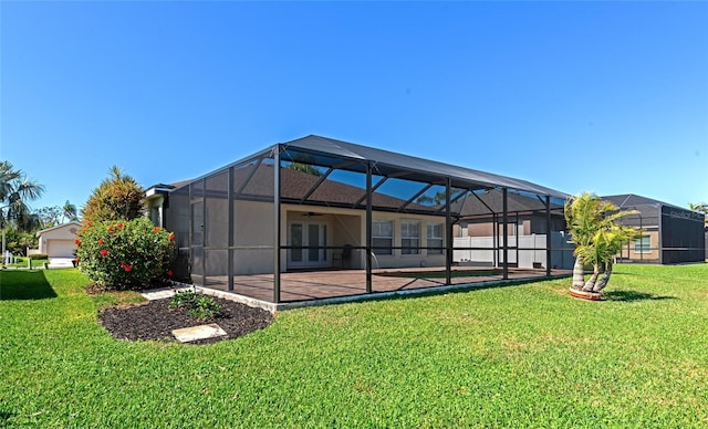 rear view of house with french doors, a lawn, a patio, and glass enclosure