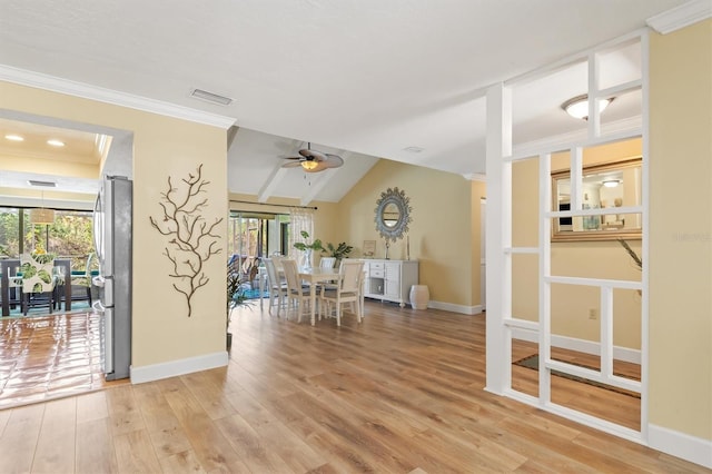 dining room with wood-type flooring, vaulted ceiling, ceiling fan, and crown molding