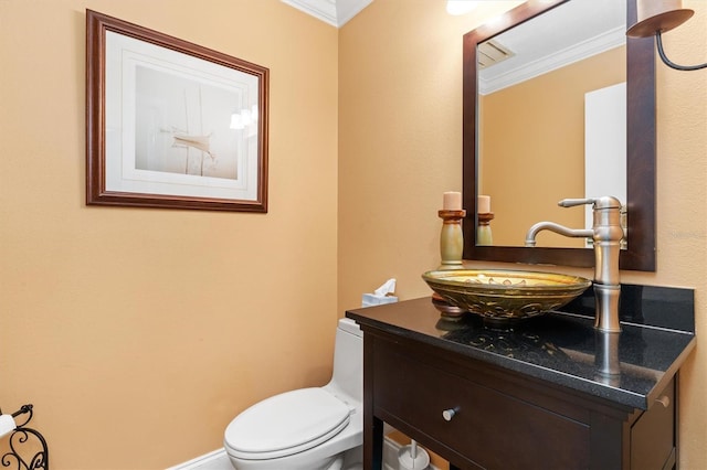 bathroom featuring vanity, ornamental molding, and toilet