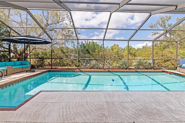 view of pool featuring an outdoor hangout area, a patio area, and glass enclosure