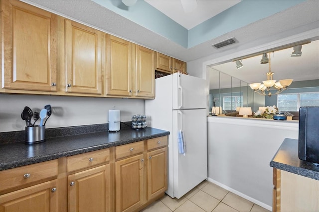 kitchen featuring light tile patterned flooring, a chandelier, white fridge, and pendant lighting