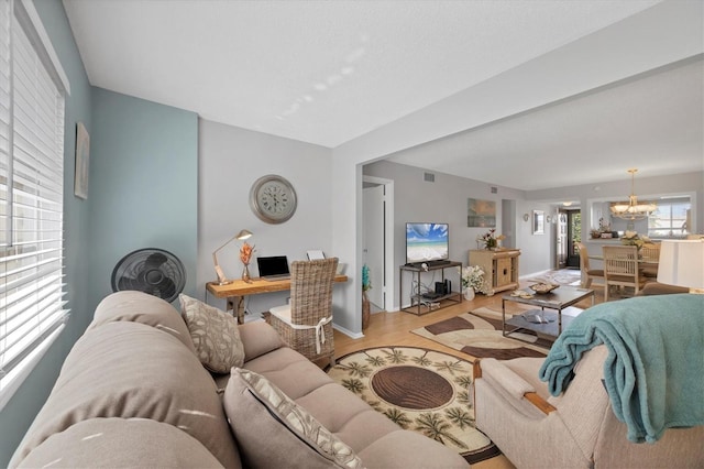 living room featuring a notable chandelier and light hardwood / wood-style flooring