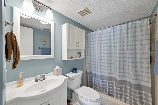 bathroom with vanity, curtained shower, toilet, and a textured ceiling