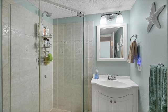 bathroom featuring vanity, a shower with door, and a textured ceiling