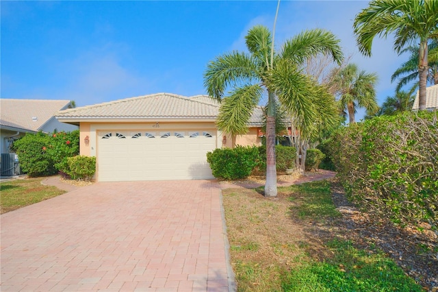 view of front of house with a garage and central air condition unit