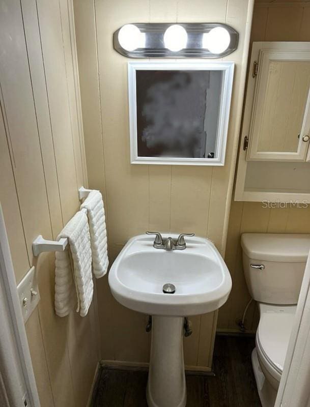 bathroom featuring wood-type flooring, toilet, and sink