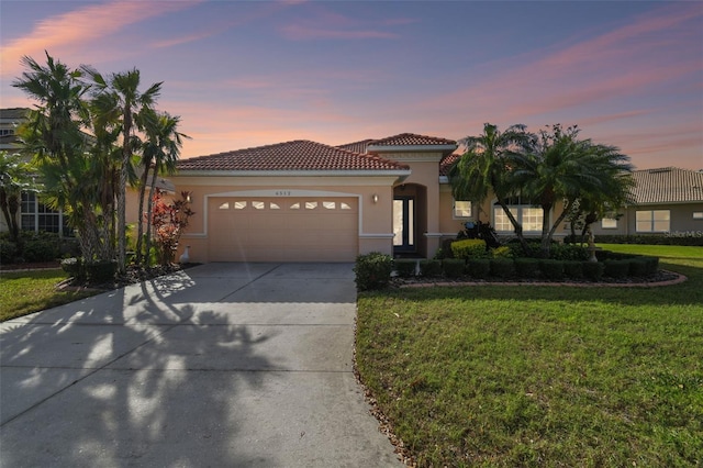 mediterranean / spanish-style home with a garage and a lawn