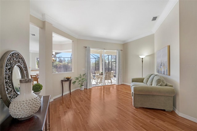 living area with crown molding and hardwood / wood-style floors