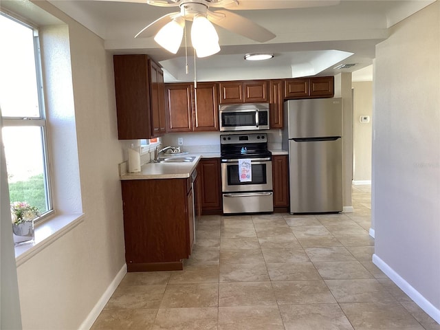 kitchen featuring sink, appliances with stainless steel finishes, ceiling fan, and light tile patterned floors