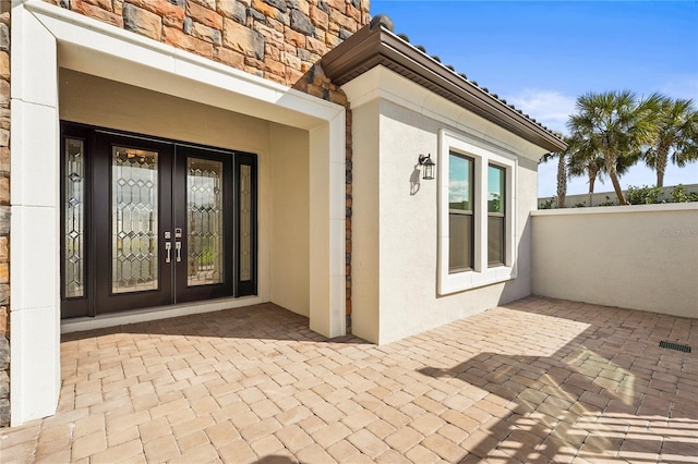 property entrance with a patio and stucco siding