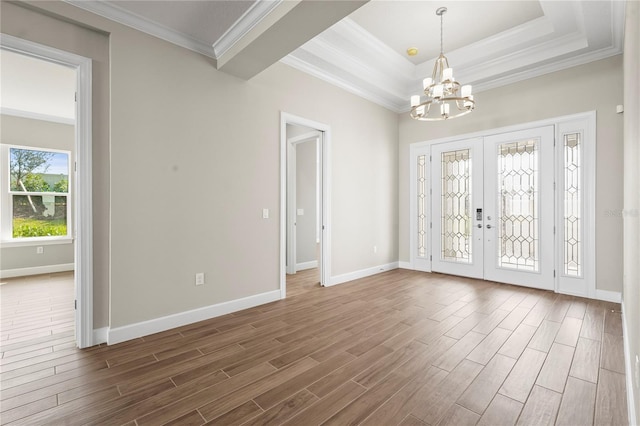 foyer with baseboards, dark wood-style floors, ornamental molding, french doors, and a chandelier