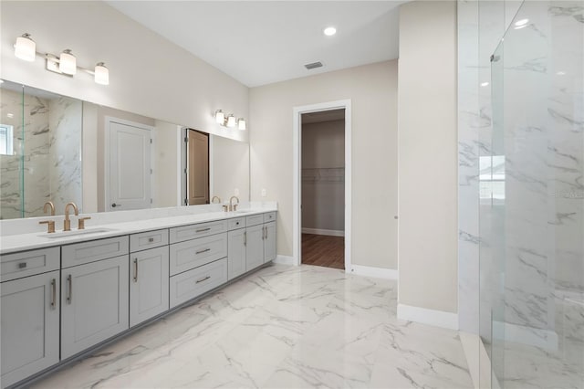 bathroom with double vanity, a marble finish shower, visible vents, marble finish floor, and a sink