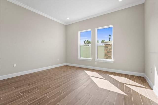 spare room featuring wood finish floors, crown molding, baseboards, and recessed lighting