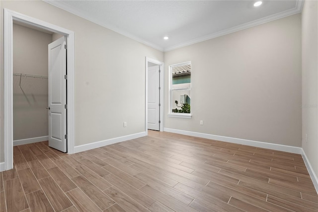 unfurnished bedroom featuring baseboards, a walk in closet, and wood tiled floor