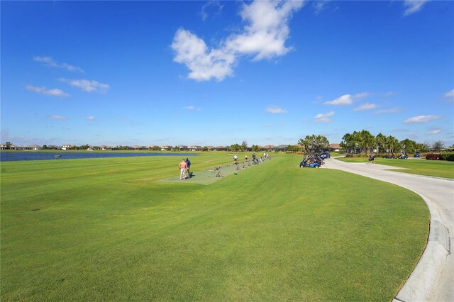 view of property's community featuring a yard, golf course view, and a water view