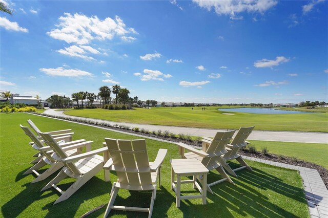 view of community with a water view, golf course view, and a yard