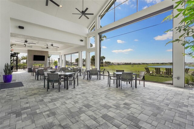 view of patio featuring a water view, ceiling fan, and outdoor dining area