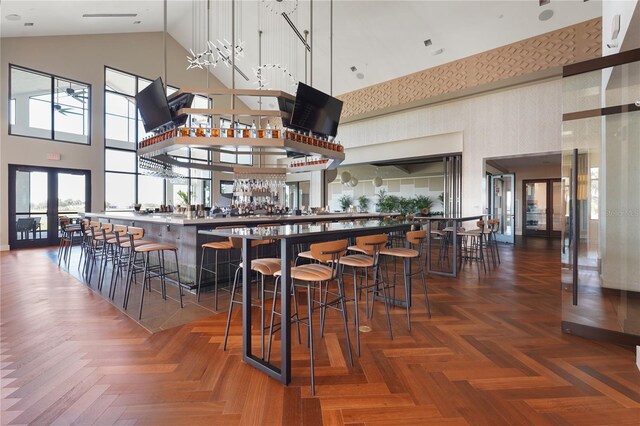 bar with a community bar, french doors, and a towering ceiling