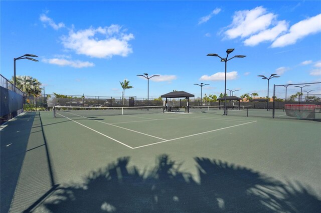 view of tennis court featuring a gazebo and fence