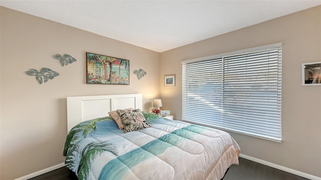 bedroom featuring dark hardwood / wood-style floors and a textured ceiling