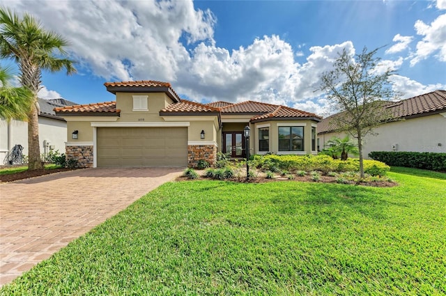 mediterranean / spanish-style house with a front yard, stone siding, an attached garage, and stucco siding