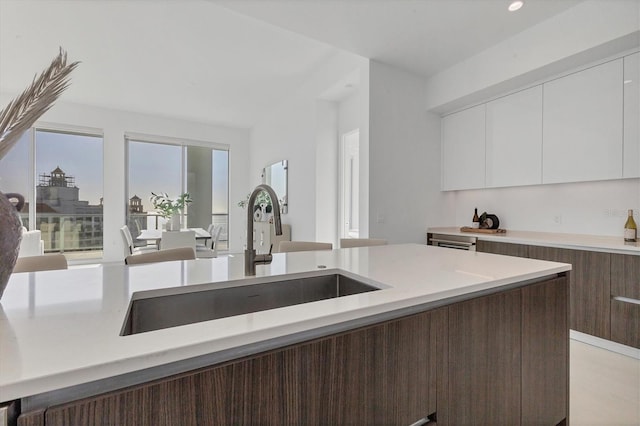 kitchen featuring white cabinetry, sink, and dark brown cabinets