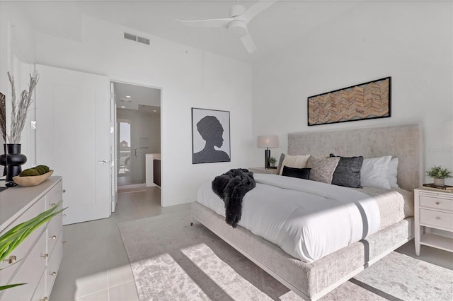 bedroom featuring light tile patterned floors, ensuite bath, and ceiling fan