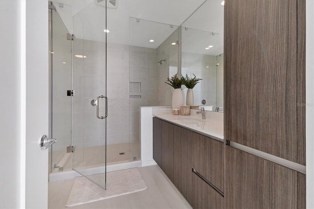 bathroom featuring a shower with door, vanity, and tile patterned floors