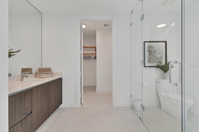 bathroom featuring tile patterned floors, vanity, toilet, and an enclosed shower