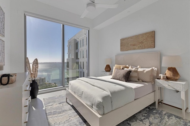 bedroom featuring a water view and ceiling fan