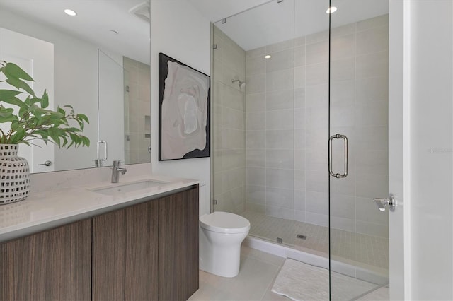 bathroom with tile patterned floors, vanity, toilet, and a shower with door