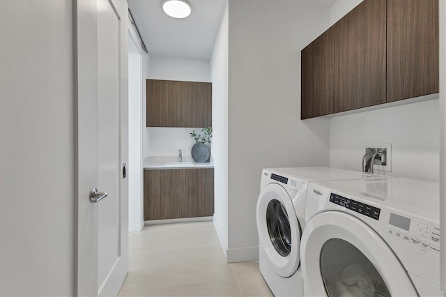 clothes washing area featuring cabinets, separate washer and dryer, and light tile patterned floors