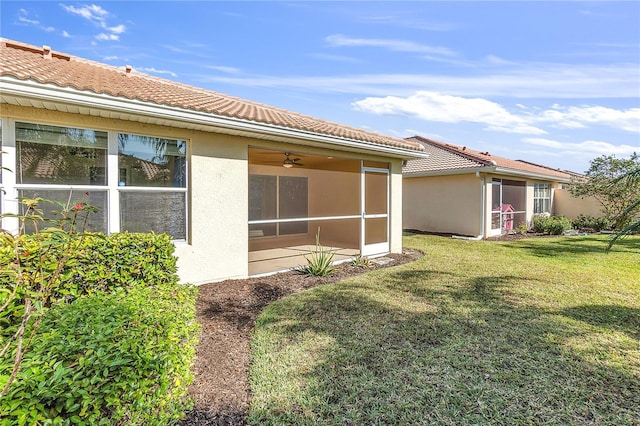 rear view of house featuring a yard and a sunroom