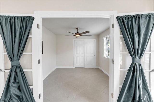 unfurnished bedroom featuring light tile patterned flooring, ceiling fan, and a closet