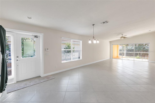 tiled foyer with ceiling fan with notable chandelier