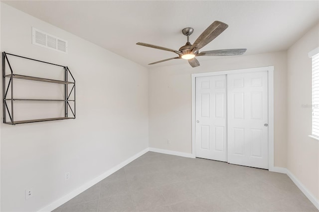 unfurnished bedroom with ceiling fan and a closet