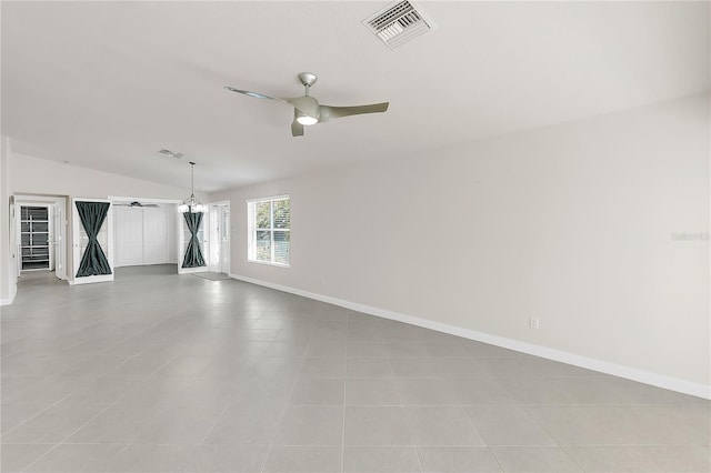 empty room featuring ceiling fan, lofted ceiling, and a barn door