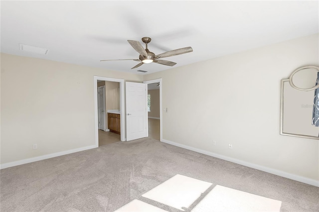 unfurnished bedroom featuring ensuite bathroom, light colored carpet, and ceiling fan