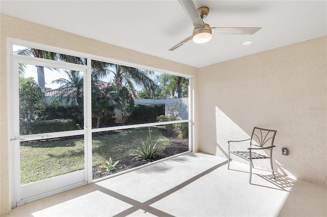 unfurnished sunroom featuring ceiling fan