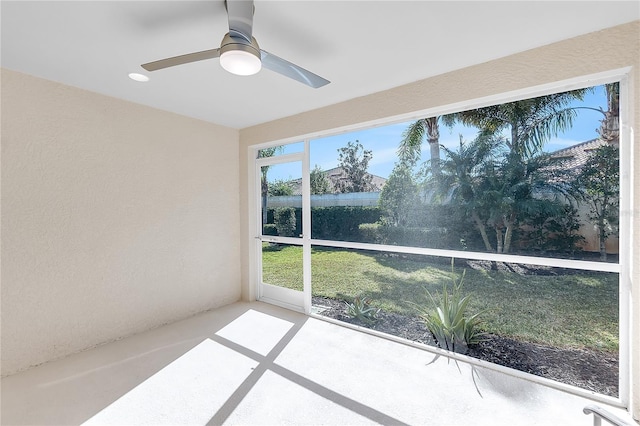 unfurnished sunroom featuring ceiling fan