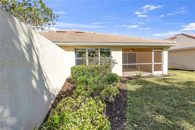 back of house featuring a yard and a sunroom