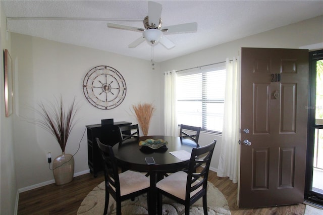 dining room with ceiling fan, dark hardwood / wood-style flooring, and a textured ceiling