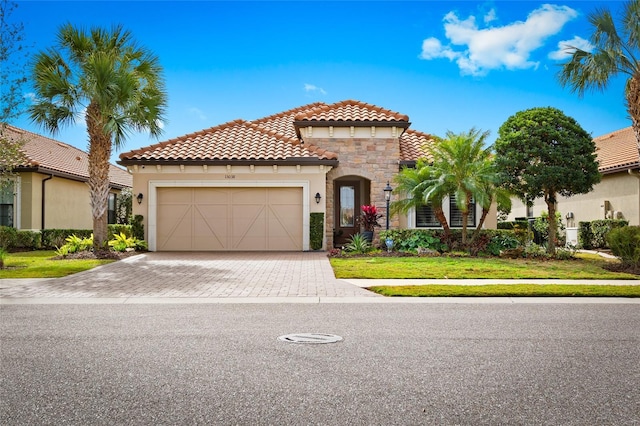 mediterranean / spanish house featuring a front lawn and a garage