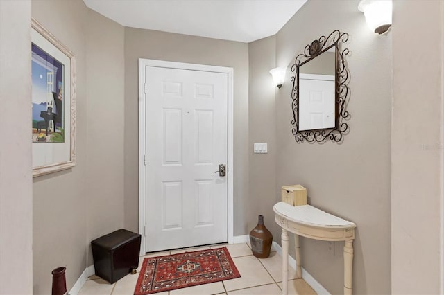 interior space with baseboards and light tile patterned flooring