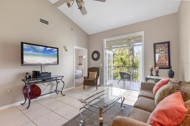 living area with visible vents, baseboards, light tile patterned floors, high vaulted ceiling, and a ceiling fan